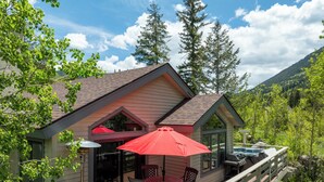 Eine Hütte mit einer Terrasse, Sitzgelegenheiten im Freien und einem Whirlpool.