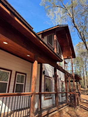 A two-story wooden house with a balcony and a covered porch. - Gorgeous New Skyfall Cabin in Broken Bow Sleeps 10 in Style with Huge Deck! (Broken Bow)