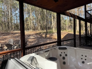 Uma banheira de hidromassagem com vista para uma área arborizada.