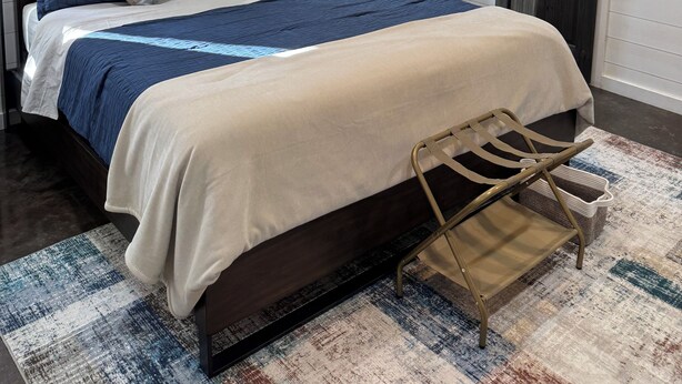 Een slaapkamer met een bed, een plafondventilator en een raam.