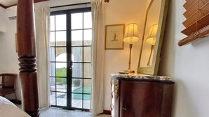 A hotel room with a large window, a wooden column, a marble-topped dresser, and a framed picture on the wall. - Romantic Private Pool Suite with outdoor tub Rincon, close to beaches (Rincon)