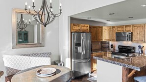 A modern kitchen with a stainless steel refrigerator, a built-in microwave, and a black stove. - Black Bear Lodge #303 | Walk to West Wall Lift, Heated Garage + Hot Tub | 2BR (Crested Butte)