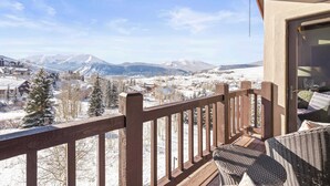 A balcony with a view of snow-covered mountains and a town. - Black Bear Lodge #303 | Walk to West Wall Lift, Heated Garage + Hot Tub | 2BR (Crested Butte)