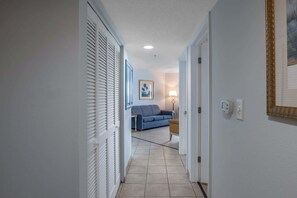 Ein Flur mit einem blauen Sofa, einer Lampe und einem gerahmten Bild an der Wand.