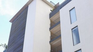 Un immeuble moderne à plusieurs étages, doté de balcons et de grandes fenêtres.