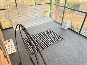 A wooden bench with a metal frame, a grey carpeted floor, and a patterned rug. - The Cabin in Moody Hollow (Hiawassee)