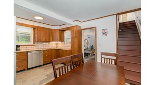 A kitchen with wooden cabinets, a dining table, and a staircase. - Hersheypark in 2 miles,w/ large private yard (Hershey)