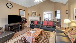 A living room with a flat-screen TV, two sofas, a coffee table, and a fireplace. - 6BR Home • Spacious Yard + Grill • Peaceful Suburb (Locust Grove)