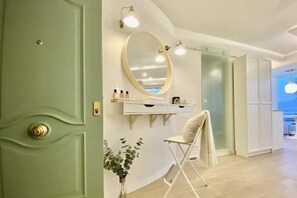 A room with a green door, a white vanity with a mirror, and a folding chair. - Your vacation home in La Carihuela - 2 minutes from the beach (Torremolinos)