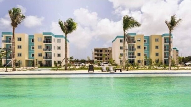 Un resort con piscina, palmeras y edificios de varios pisos.