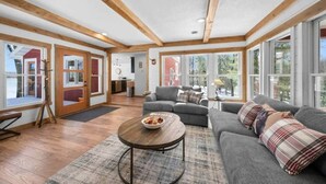 A spacious living room with a grey sofa, a round coffee table, and a wooden floor. - Mallard Lake Retreat (Jackson)