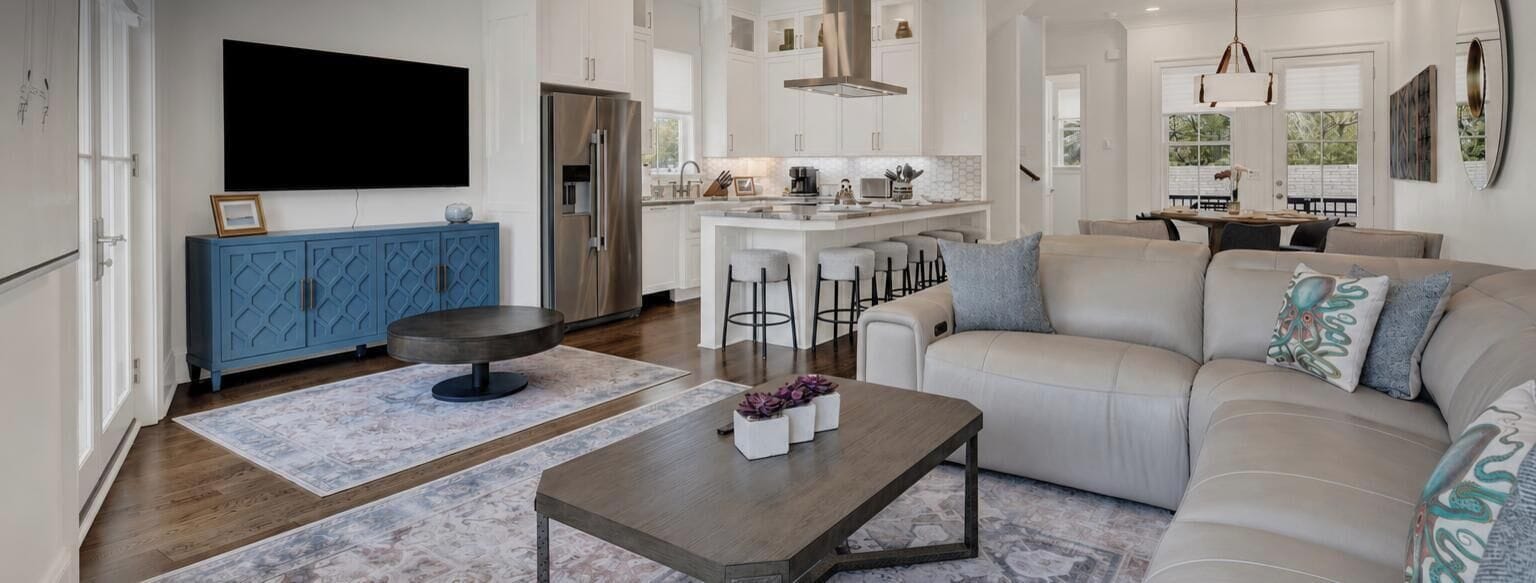 A modern living room with a sofa, coffee table, and bar stools.