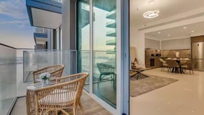 Un intérieur moderne avec un balcon, des meubles en osier et un coin cuisine.
