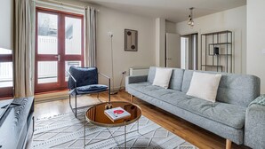 En moderne stue med en grå sofa, en blå lænestol og et sofabord.