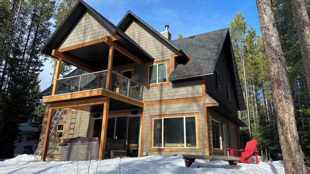 A two-story house with a balcony, large windows, and a wooden deck. - Cabin at Idabel Family, Pet Friendly with Games Room (Kootenay Boundary E / West Bo*)