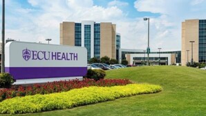 Segnaletica per ECU HEALTH con un edificio moderno sullo sfondo.