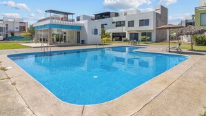 A swimming pool with a clear blue water surface, surrounded by a concrete deck. - Seaport | Family Home and Shared Pool (Puerto Vallarta)