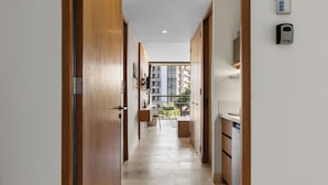 A hallway with wooden doors, a small seating area, and a view of a balcony. - Bright studio at Hotel Mio with pool (Bucerías)