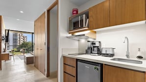 A modern kitchen with wooden cabinets, a built-in microwave, a coffee maker, and a dishwasher. - Bright studio at Hotel Mio with pool (Bucerías)