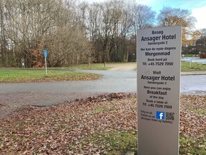 Une enseigne pour l’hôtel Ansager, avec les coordonnées et un code QR.