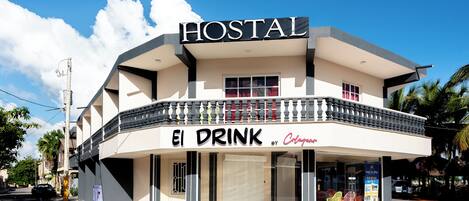 A building with a sign reading "HOSTAL" and "El Drink by Colgate."