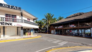 A building with a sign that reads "POSTAL" and a storefront with a sign that reads "DRINK BY O'Gara's". - Hotel Boca de Yuma (Boca de Yuma)