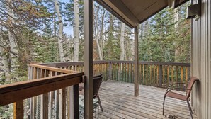 A wooden deck with a railing, a chair, and a table. - Ski Access SS7B Retreat Pet Friendly  (Brian Head)