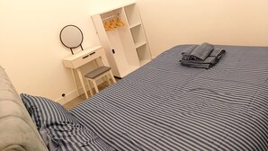 A bedroom with a bed, a desk, a chair, a wardrobe, and a mirror. - Cardiff Cozy One Bedroom Apartment (Cardiff)