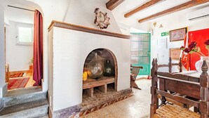 A room with a fireplace, a wooden bench, and a green door.