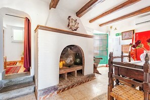 A room with a fireplace, a wooden bench, and a green door. - Summer Country Retreat w/ Hot Tub, Fire Pit & Garden Views (Bassano In Teverina)