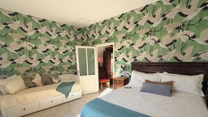 A bedroom with a bed, a nightstand, a dresser, and a wardrobe.