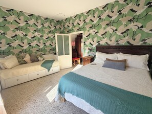 Ein Schlafzimmer mit Bett, Nachttisch, Kommode und Kleiderschrank.