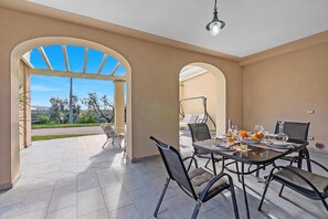 A dining area with a table set for four, surrounded by chairs, and a view of the outdoors through an archway. - Great Panoramic View Pino Pool & Relax, Lamporecchio, Italy (Lamporecchio)