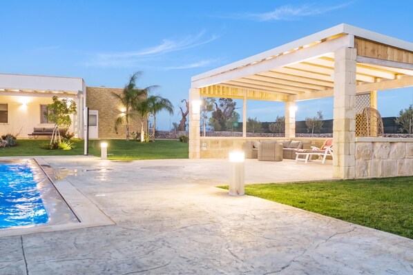A modern outdoor patio area with a pool, seating, and a pergola. - Trullo Tenuta Mary with Heated Pool, Carpignano Salentino, Italy (Carpignano Salentino)