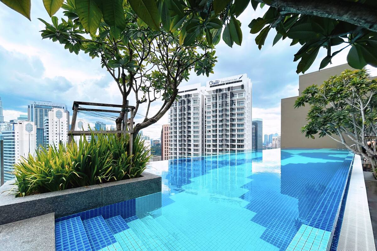 A modern infinity pool with a city skyline in the background.