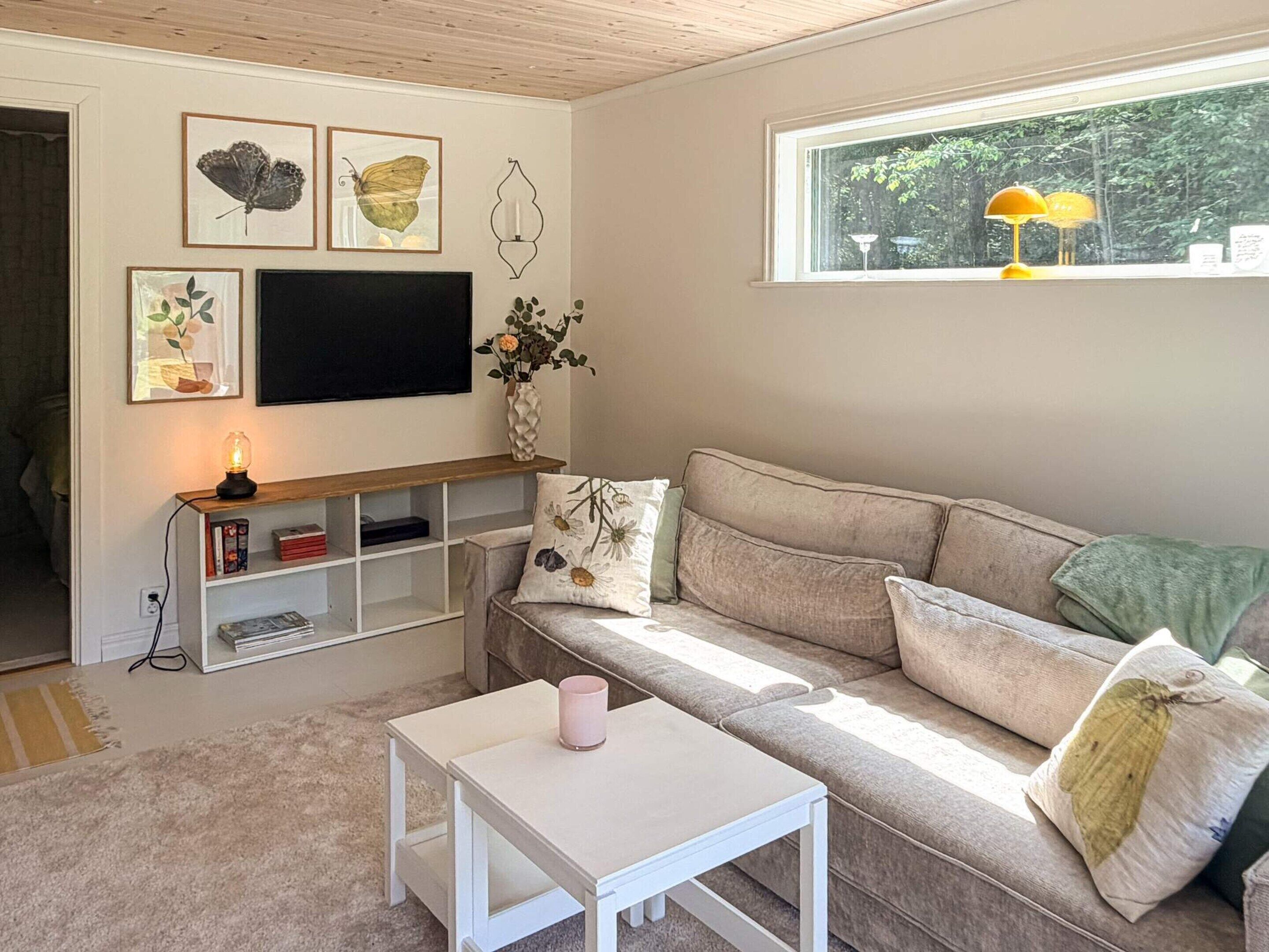 A living room with a sofa, a coffee table, a TV, and a bookshelf.