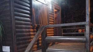 A wooden cabin with a metal roof, a staircase leading to a porch, and a door visible in the background. - Cabañas Misioneras  (San Ignacio)