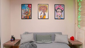 A room with a grey sofa, two side tables, and three framed artworks on the wall. - 1BR-1AC Stylish Studio near Provenza&Parque Lleras (Medellín)