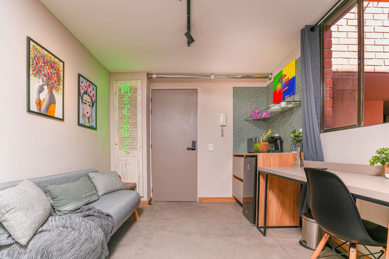A compact living space with a sofa, a kitchenette, and a dining area.