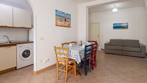 A compact living space with a kitchen, dining area, and a sofa. - Vanna, in Marina di Campo, close to the pedestrian area and to the beach, far from the noise of the (Campo nell'Elba)