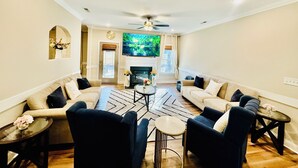 A living room with a fireplace, two sofas, a coffee table, and a TV.