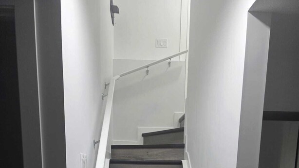 Eine Treppe mit Holzstufen und weißen Wänden.