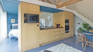 A modern interior with a kitchen, dining area, and a staircase. - Sparrows Nest - UK50109 (Sparrow Green, near Dereham)