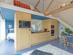 Ein modernes Interieur mit einer Küche, einem Essbereich und einer Treppe.