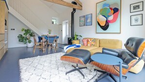 A spacious living area with a high ceiling, a staircase, and a dining area with a table and chairs. - Sparrows Nest - UK50109 (Sparrow Green, near Dereham)