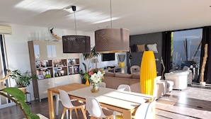 A modern living space with a dining area, kitchen, and seating area.