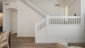 A staircase with white railings and a landing area with a white bench and a small table. - Modern, Spacious & Peaceful 4B/3B House (Chandler)