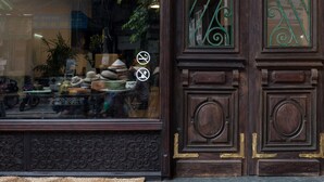 A wooden door with intricate carvings and a metal gate. - Centraltique Downtown Living (Hanoi)