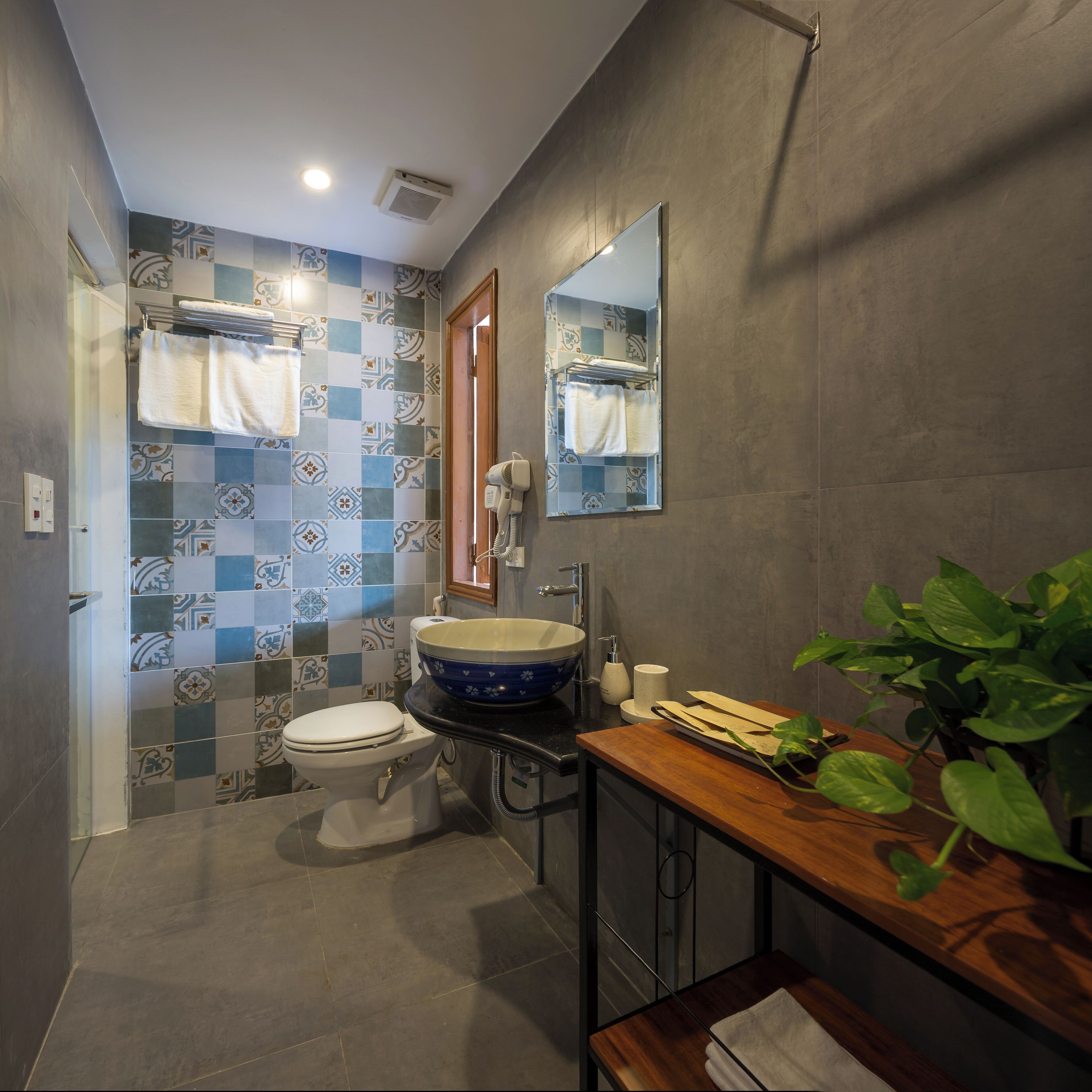 A bathroom with a toilet, sink, and mirror.