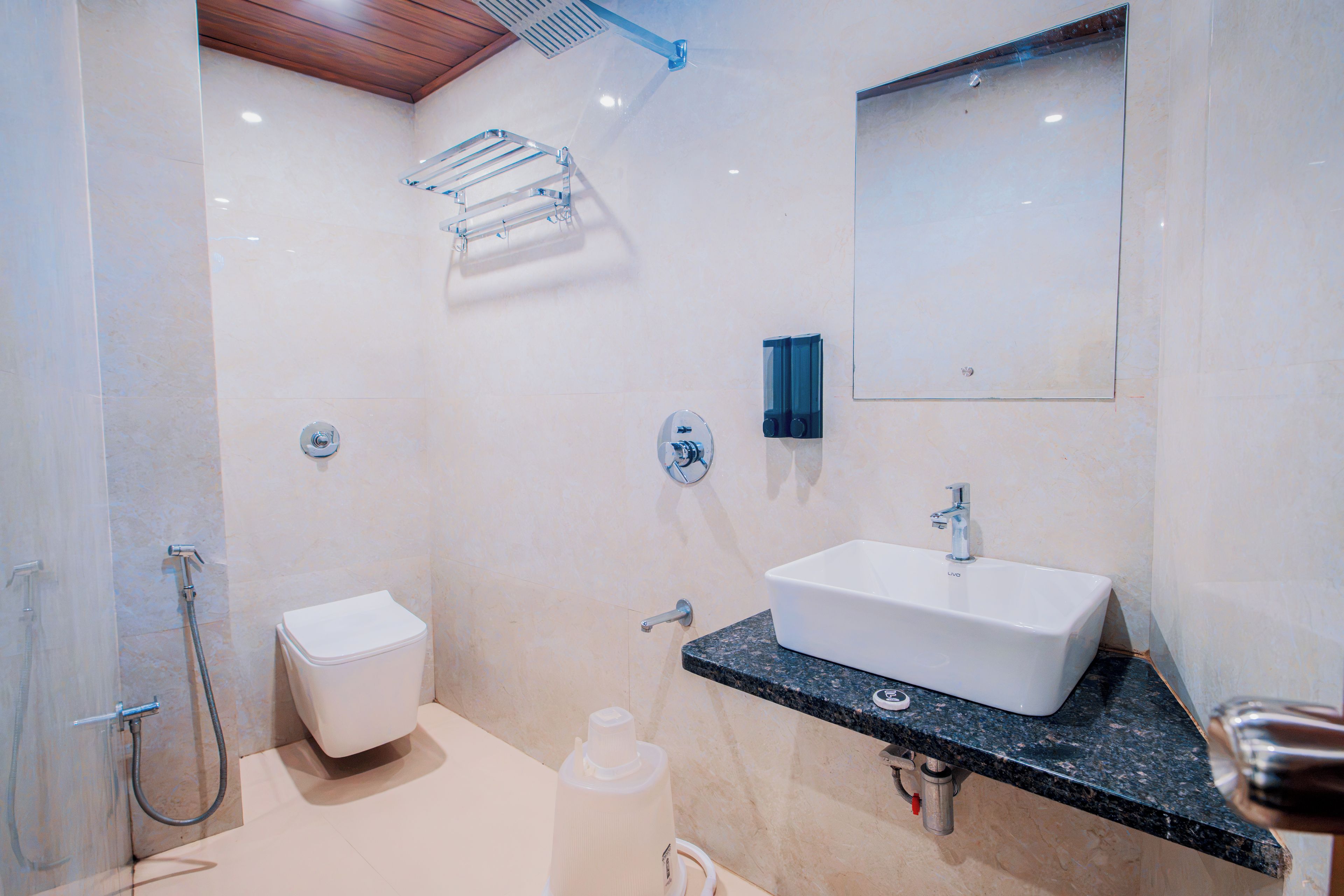 A modern bathroom with a white sink, a toilet, a shower, and a towel rack.